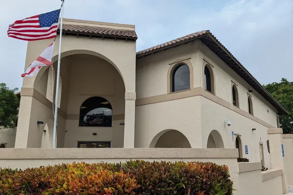 Downtown Boca Raton's old public library building, arched entrance and flags